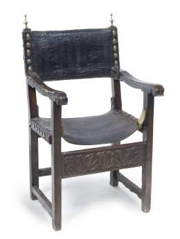 909.  Frailero en madera de nogal, el asiento y respaldo de piel.Trabajo español, h. 1.600.