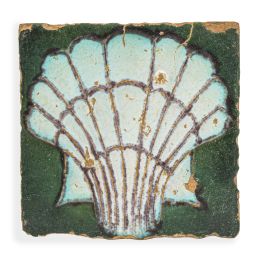 647.  Azulejo de cerámica esmaltada de arista con venera sobre fondo verde.Sevilla, S. XVI.