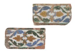 606.  Dos azulejos de arista de cerámica esmaltada, con hojas y roleos, en azul, verde y melado.Triana, S. XVI.