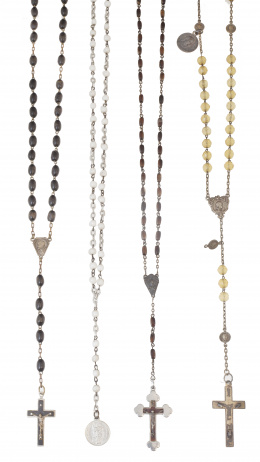 61.  Lote de cuatro rosarios con cuentas de diferentes materiales en plata y metal