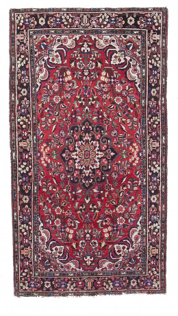 1006.  Alfombra en lana de campo rojo y elementos vegetales, Persia, S. XX.