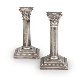 509.  Pareja de candeleros en metal plateado, con forma de columnas.Inglaterra, S. XX.