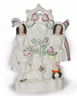 710.  Pareja de escoceses.Figura de loza esmaltada que simula un reloj.Staffordshire, Inglaterra, ff. del S. XIX.
