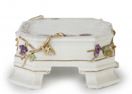 731.  Peana en porcelana esmaltada, con aplicaciones de pámpanos en amarillo, malva y dorado. Marcado en la base en azul.Buen Retiro, (1760-1784).