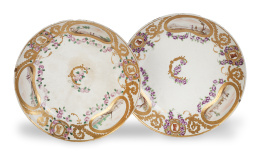 735.  Pareja de platos de la vajilla de los Príncipes de Asturias, esmaltada y dorada. Sigue los modelos de la manufactura de Sévres. Con marca en azul en la base, uno de ellos con "P" incisa.Buen Retiro, (1775-1784).