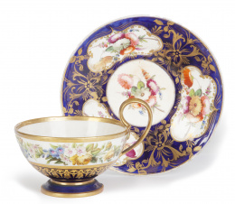 1058.  Taza y platito en porcelana esmaltada con decoración floral. S. XIX.