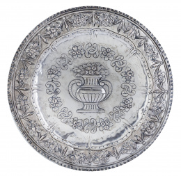 1344.  Bandeja circular en plata repujada con un jarrón con flores.S. XIX.