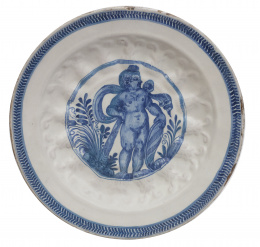 574.  Plato de cerámica en azul cobalto con un niño inserto en cartela en el asiento.Italia, S. XVII.