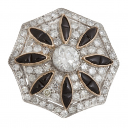 323.  Sortija estilo Art-Decó, con gran frente de ónix y brillantes en forma hexagonal a modo de paraguas, y centro de brillante de 0,96 ct