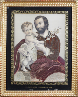 1135.  San José en bordado de hilos y grabado coloreado.Con marco de madera tallada y dorada.Firmado "Sara de Anca y Merlo Año 1858".