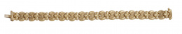 135.  Pulsera articulada de piezas en forma de cruz y de lazo, en oro brillo y mate combinados