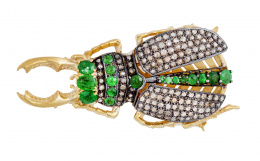 344.  Broche en forma de escarabajo completamente cuajado de diamantes, con esmeraldas adornando cabeza y línea entra las alas de diamantes