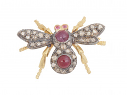 65.   Broche mosca con cuerpo de rubíes cabuchón orlados de diamantes, y alas de diamantes