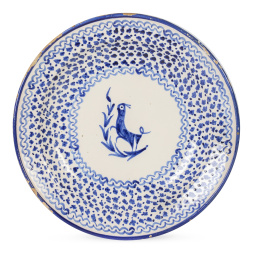 517.  Plato de cerámica esmaltada en azul con un perro en el asiento, marcado con A en el reverso.Fábrica de Arenes, Manises, S. XIX.