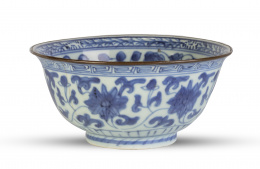 562.  Cuenco de porcelana esmaltada en blanco y azul con borde metálico decorado con peonías. China, dinastía Quing S. XVIII. 