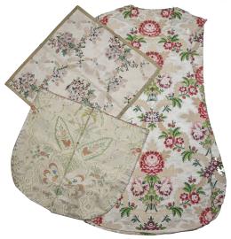 1062.  Lote de tres piezas: casulla, cubre cáliz y paño con forma de escudo de la la capa pluvila en seda con flores bordadas en hilos de color y en oro.España, S. XVIII.