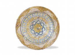 613.  Plato de cerámica esmaltada en azul de cobalto y reflejo dorado. Manises, S. XIX.