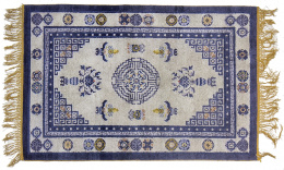 705.  Alfombra china en lana de campo blanco y decoración en azul, S. XX.
