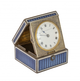 666.  Robert Linzeler (1872-1941)*.Caja art decó en plata dorada decorada en esmalte guilloché en azul con reloj despertador de viaje. Con marcas.París, primer cuarto del S. XX.