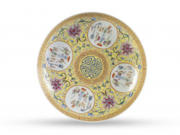 841.  Plato de porcelana esmaltada en amarillo con reservas decorativas de "hundred antiques". Con marca en el reverso.China, ff. del S. XIX.