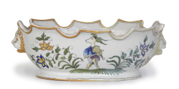 1079.  Centro de cerámica esmaltada con flores y personaje fantástico.Francia, Moustiers, S. XX.
