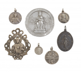 20.  Lote formado por 13 medallas,rosario, rosario de anillo con cadena de de plata y tres cruces en metal plateado