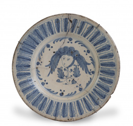 1095.  Plato de cerámica esmaltada en azul de cobalto, decoración de espigas en el alero y cabeza en el asiento.Teruel, S. XVII. 
