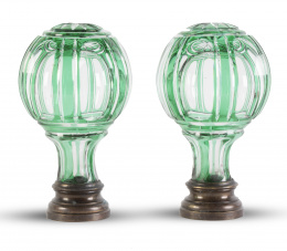 1119.  Pareja de remates de escalera en cristal verde y transparente facetado sobre base de metal.pp. del S. XX.