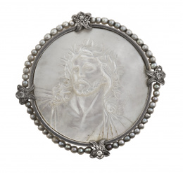 78.  Broche años 30 con busto de Cristo con corona de espinas tallado en nácar, rodeado de marco de perlitas finas
