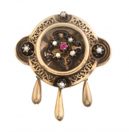 10.  Broche circular de finales del S. XIX con marco calado, centro de perlas y rubí y perlas en puntos cardinales