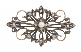 27.  Broche de finales del S. XIX con centro de flor, con perla entre motivos vegetales adornados con diamantes