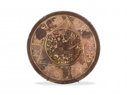 683.  Plato de cerámica esmaltada de reflejo metálico con un pajarito y decoración de hojas rayadas.Manises, S. XVIII.