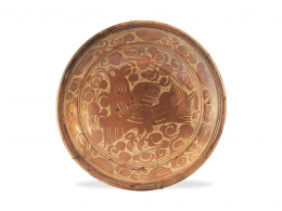 680.  Plato de cerámica esmaltada de reflejo metálico, con pájaro entre hojas.Manises, S. XVIII.