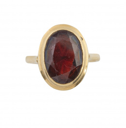 96.  Sortija años 50 con granate de talla oval en montura escalonada con galería calada