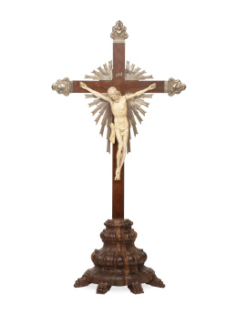 1160.  Cristo en marfil tallado sobre cruz de madera de palosanto, remates de plata, ley 925, Portugal, S. XX.El Cristo de marfil tallado, S. XVIII - XIX.