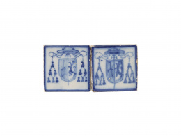 444.  Pareja de azulejos de cerámica esmaltada en azul de cobalto, con el escudo del Monasterio de San Lorenzo de el Escorial bajo capelo cardenalicio. Talavera, S. XIX.