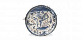 479.  Plato de cerámica esmaltada en azul y manganeso decorado con un dragón entre ramas y una mariposa.Talavera, S. XVIII.