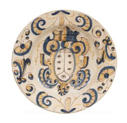 1164.  Plato de cerámica esmaltada de la serie tricolor con el escudo del Monte Carmelo, rodeado de cueros recortados.Talavera, S. XVII.