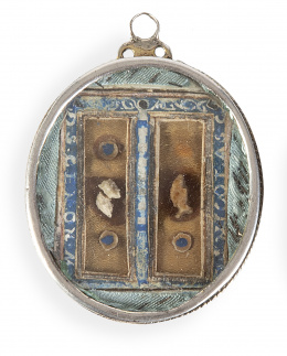 503.  Relicario con dos vitrales, anverso con reliquias, papel pintado, hilo azul y metálico; reverso con la Virgen y el Niño Jesús pintados sobre papel; marco de plata con cordoncillo.Trabajo español, S. XVIII.