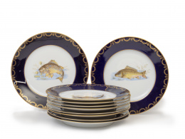 1003.  Juego de diez platos de porcelana esmaltada en azul y dorado con decoración de un pez pintado.Prinken Hammer, Checoslovaquia.