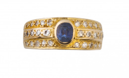 186.  Sortija con zafiro azul de talla oval central en montura con tres líneas de brillantes