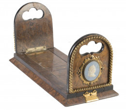 1107.  Sujeta libros Luis Felipe de madera de raíz, con dos tondos clásicos de biscuit y bronce aplicado.Francia, h. 1840.