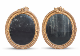 1175.  Pareja de espejos ovales regencia en madera tallada y dorada.Trabajo francés, pp. del S. XVIII.