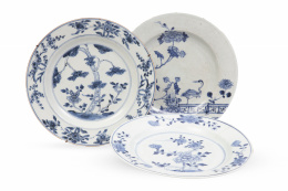 1228.  Lote de tres platos de porcelana esmaltada de Compañía de Indias en azul y blanco con garzas y peonías.China, S. XVIII.