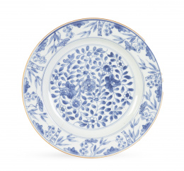 1166.  Plato de porcelana esmaltada en azul y blanco con decoración floral.Compañía de Indias, China, S. XVIII.