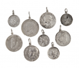 233.  Lote de nueve monedas y medallas colgantes de plata