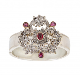 238.  Brazalete con motivo central de diamantes de diseño de roléos, adornado con granates talla cabujó y pera