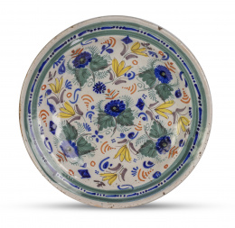 779.  Plato de cerámica esmaltada decorada con flores en azul, verde y amarillo.Manises, S. XIX.