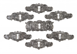 1220.  Lote de siete bocallaves de plata, decorados con escenas cinegéticas, arquitecturas y otro con dos escudos, S. XVIII.