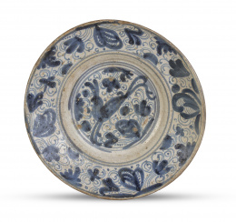 1162.  Plato acuencado de cerámica esmaltada en azul de cobalto con una liebre y flores y hojas en el alero.Teruel, S. XVIII.